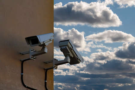 Security camera on the blue wall in summer day