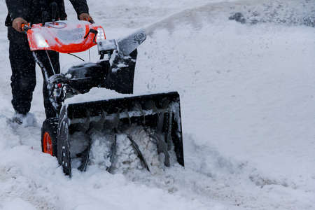 The person deletes snow after snowfall with the rotor snowplowの写真素材