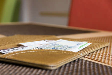 the cover for money lying on a little table in cafe near coffeeの写真素材