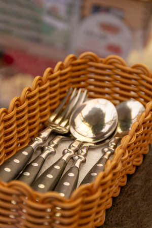 Cutlery in a beautiful braided basket on a restaurant table