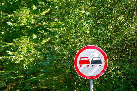 no overtaking sign on a background of trees on a clear summer dayの写真素材