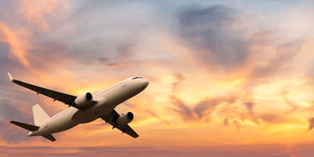 passenger plane takes off in a beautiful sunset sky in summerの写真素材
