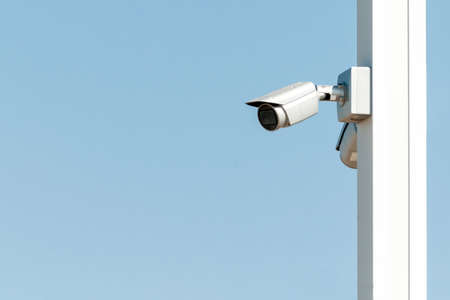 Security camera on the blue wall in summer clear day