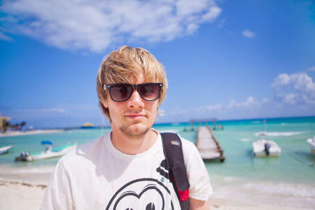 Portrait of a young man santing on the beachの写真素材