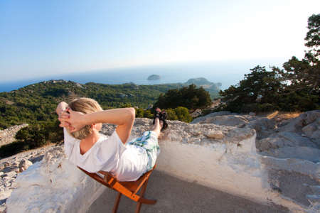 Young man enjoys the view of a lanscape and seaの写真素材