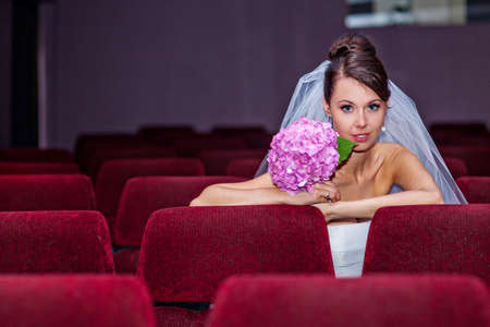 Young bride on her wedding day in a movie theatreの写真素材