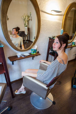 Young woman sitting at hairdressers and waitingの写真素材