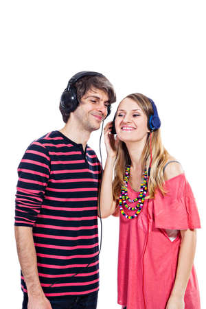 Happy young couple listening to a music isolated on a white backgroundの写真素材