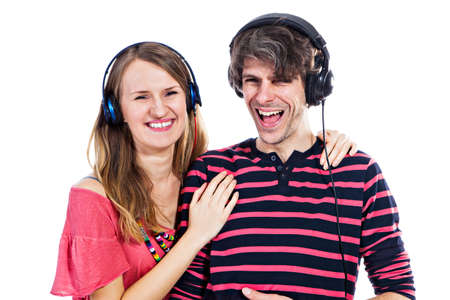 Happy young couple listening to a music isolated on a white backgroundの写真素材
