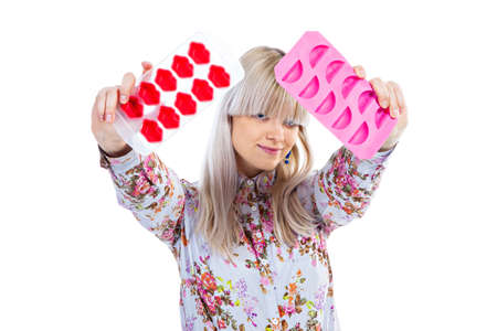 Beautiful blond girl holding ice moulds isolated on white backgroundの写真素材