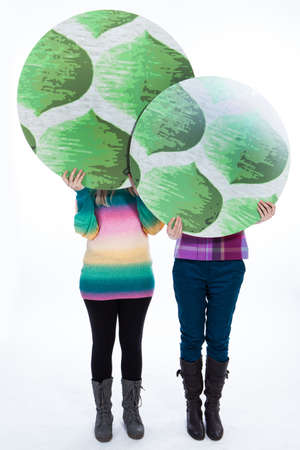 Two women holding tree signsの写真素材