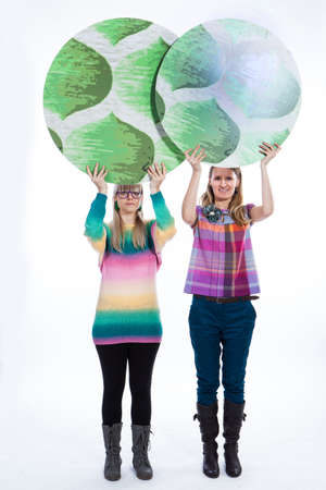 Two women holding tree signsの写真素材
