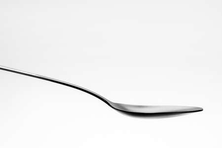One single black spoon on white backgroundの写真素材