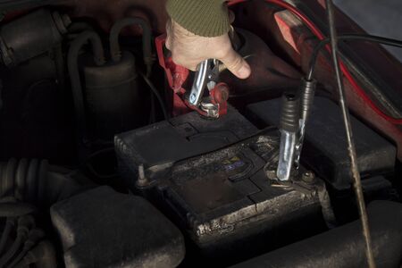 Mechanic jumper cables connected to a battery Discharged. Firing the car in the winter by the jumper cables.の写真素材
