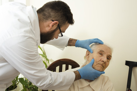 The doctor geriatrician during the test. Doctor examines changes in the skin of an old woman.の写真素材