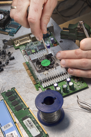 Repair the graphics card. Unscrewing the cooling fan. Service on a computer service.