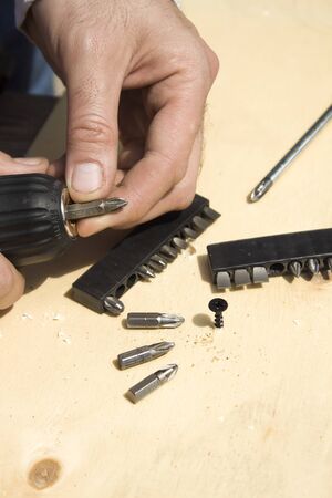 The carpenter's hands changing the tip of the tip in the screwdriverの写真素材