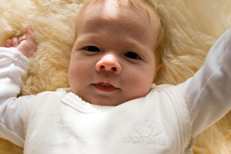 newborn happy sweet baby on furry blanket in soft colorsの写真素材