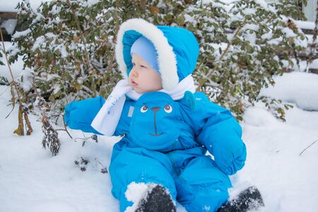 A baby sitting in a snowの写真素材