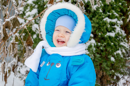 Happy baby boy is glad to snow - winter holiday outing for childrenの写真素材