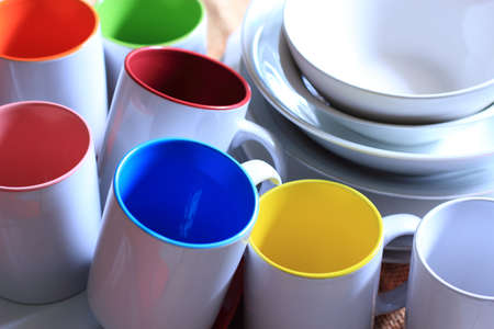 Mugs with different colors and ceramic bowlsの写真素材