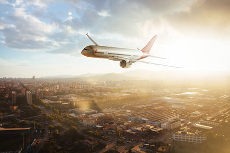 Side view of a commercial airplane flying over urban areas at sunset. Blend of 3D and raster imagesの素材