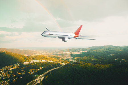 Side view of a commercial airplane flying over urban areas at sunset. Blend of 3D and raster imagesの素材