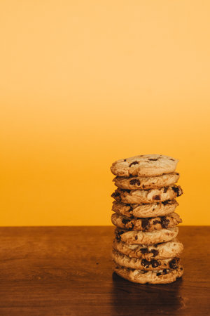Inviting breakfast scene: cookies and milk on a rustic table with an orange backdrop. Perfect for marketing.の写真素材