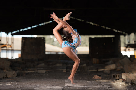 Young girl performing rhythmic gymnastics exercises outdoorsの写真素材