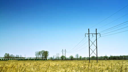High voltage electrical power line in the field with abandoned shuttle buses