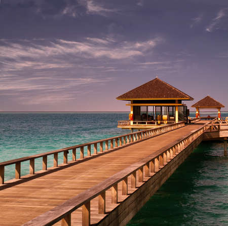 Landscape photo of Island in ocean, overwater villa with endless swimming pools. Maldives. 