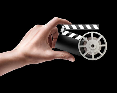 Man's hand holding Film clap board isolated on black background 
