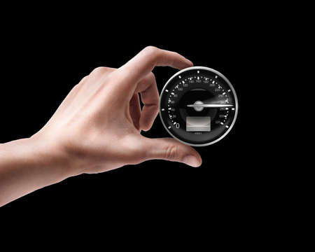 Man's hand holding Speedometer isolated on black background の写真素材