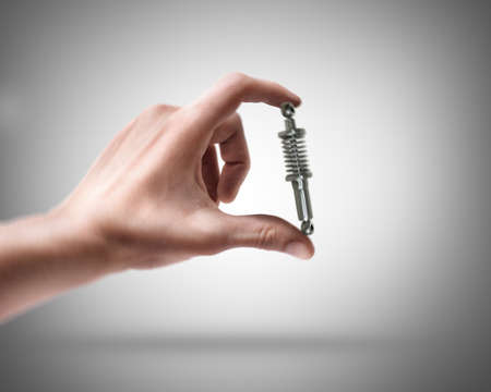 Man's hand holding shock absorber