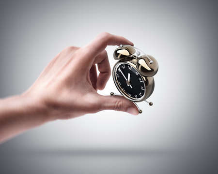 Man's hand holding Alarm clockの写真素材