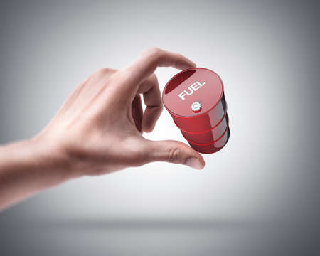 Man's hand holding red fuel barrel 