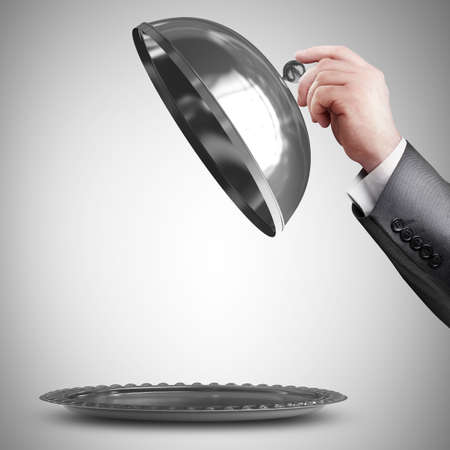 businessman hand holding silver platter or cloche with space to place object の写真素材