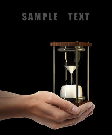hourglass sand clock. Man hand holding object isolated on black background. High resolution の写真素材