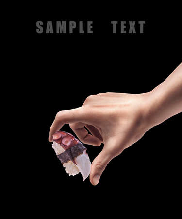 Man hand holding sushi isolated on back background. High resolution の写真素材