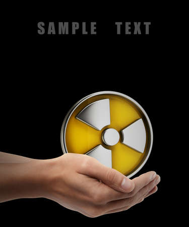 Radiation Alert sign. Man hand holding object isolated on black background. High resolution の写真素材