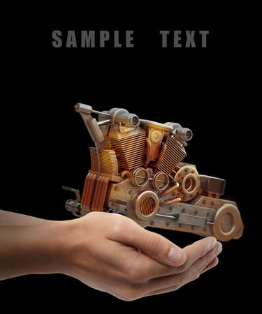 chromed motorcycle engine. Man hand holding object  isolated on black background. High resolution 