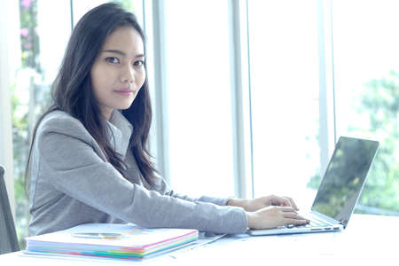 Smart asian business female working with review document at office buildingの写真素材