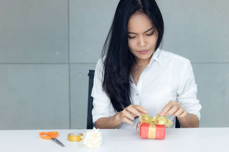 woman is wrapping up a present for Christmas or New Yearの写真素材
