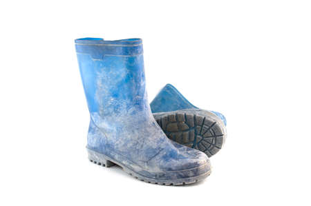 dirty rubber boots isolated on white backgroundの写真素材