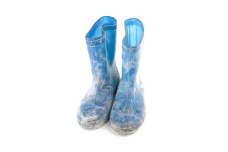 dirty rubber boots isolated on white backgroundの写真素材