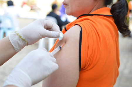 Doctor giving an injection to a patientの写真素材