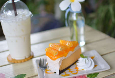 Fresh cold milk with orange cake on wooden tableの写真素材