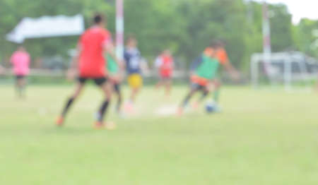 blur young children playing soccer on green soccer pitchの写真素材