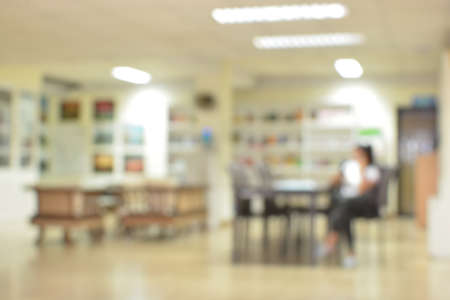 Woman sitting on chair in libraryの写真素材