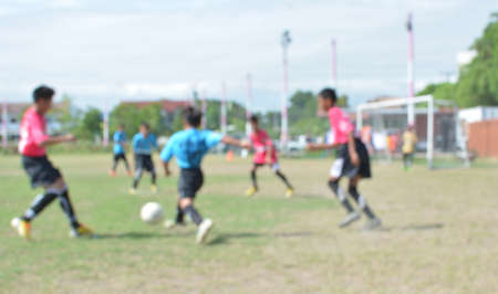 blur young boys playing soccer match on turf.の写真素材